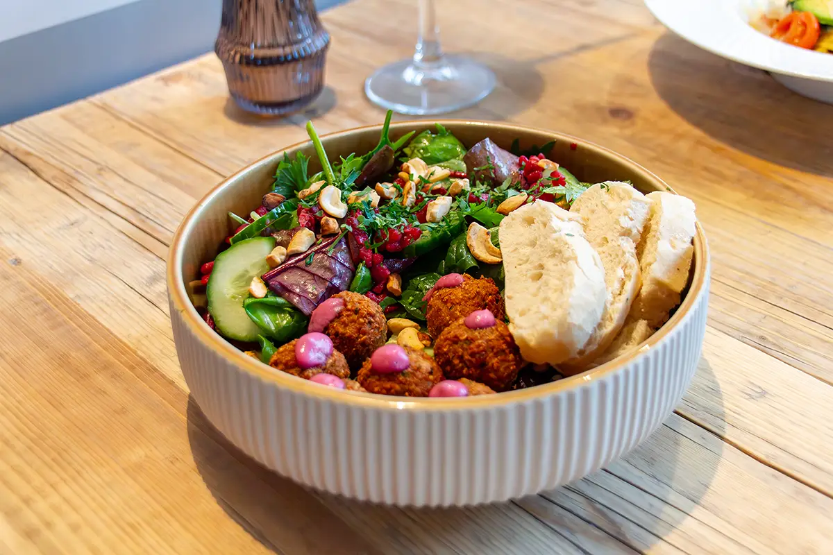 Knusprige Falafelbällchen mit mariniertem Spinat, Tomate, Quinoa, Granatapfelkernen, Cashewkernen und Rote Beete Minz Dip